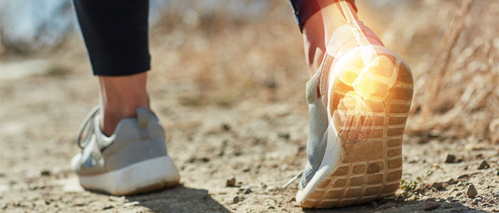 Woman walking with heaal pain highlted