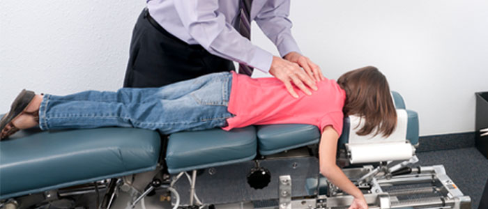 doctor checking young girl's spine